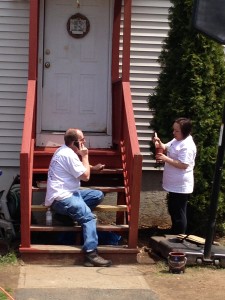 SHA Mechanic Richard Daigneault and Executive Department Manager Isabel Serrazina paint the back steps at 266 Tyler Street, Springfield.