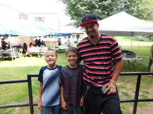 Johniell Munoz helps his stepsons Angel and Miguel Guzman get backpacks and supplies at Duggan Park Apartments back to school party.