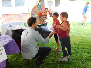 David Feinstein, literary educator at the Eric Carle Museum, with two young residents of Duggan Park Apartments at the roulette wheel.