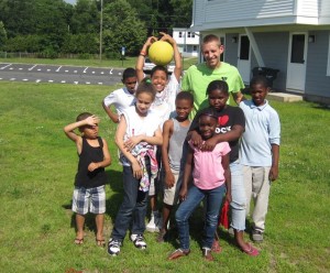 YMCA staff Christopher Kaufmann takes a break from the fun with a group of children at Robinson Gardens Apartments.