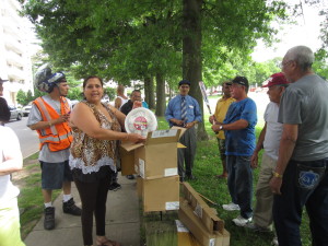 Saab Court resident Sandra Rodriguez helps to open boxes of baseball equipment donated by the sheriff's office.
