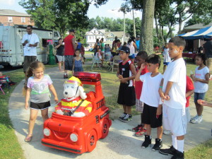 Children at Sullivan Apartments engage in fire safety talk with Springfield Fire Department's remote-controlled mascot.