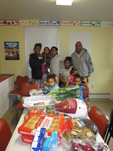 Latisa Gasque, resident at Robinson Gardens Apartments, with her children and their Thanksgiving dinner. At right is Springfield Housing Authority Youth Engagement Coordinator Jimmie Mitchell.