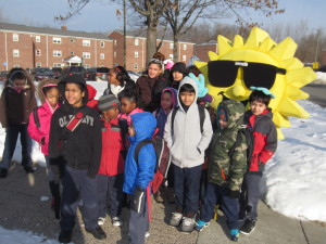 Children at Springfield Housing Authority's Sullivan Apartments stand with 'Sunny,' before walking in tandem up the hill to Boland Elementary School.
