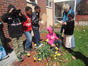Children use binoculars, mark off a check list and observe nature with Karen Guillette at Springfield Housing Authority's Riverview Apartments.