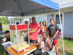 Springfield Housing Authority Youth Engagement Coordinator Jimmie Mitchell runs the popcorn machine at the Spring Fling at Robinson Gardens Apartments.