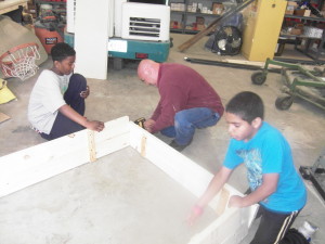 Custodian Paul Pereira gets help from children at Sullivan Apartments building forms for a garden.