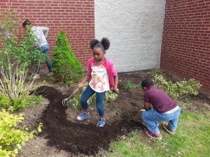 Young gardener Kiara Lee helps with planting at Sullivan Apartments.