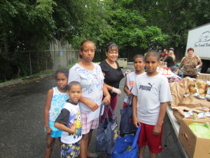 Moxon Apartments resident Eulalia Reyes and her children and their groceries from the Western Massachusetts Food Bank.