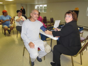 Central Apartments resident Sergeo Cedeno has his blood pressure read by Porchlight Home Care Nurse Case Manager Bernadette Duncan.