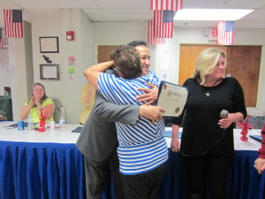 Frida Venage gives a hug to incoming state Rep. Carlos Gonzalez.