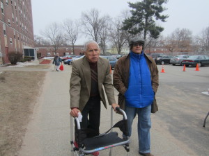 Friends Eddie Cruz and Candido Rodriguez outside Springfield Housing Authority's Riverview Apartments, ready to collect fresh produce and groceries from The Food Bank of Western Massachusetts' Mobile Food Bank.
