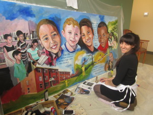Artist Rachel Saloio creating the Talk/Read/Succeed! mural for Springfield Housing Authority.