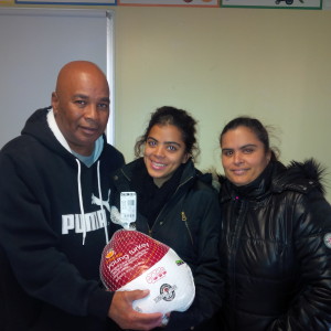 Robinson Gardens Youth Engagement Coordinator Jimmie Mitchell with Yarelis Rivera, 17, and her mother, Maria Rivera Ortiz, and their Thanksgiving turkey.