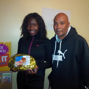 Racquel Sewell, 16, holds a ham as she stands with Youth Engagement Coordinator Jimmie Mitchell.