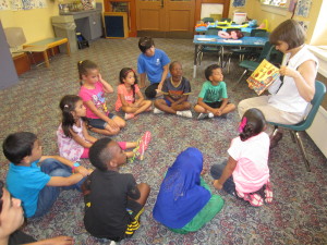 Christin Larocque, youth and outreach supervisor at the Springfield City Library, reads 'Tunjur! Tunjur! Tunjur!' a Palestinian folktale, to children from the summer learning program at Sullivan Apartments on a recent visit.