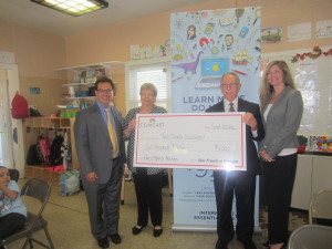 John Bairos of Comcast, SHA Director of Resident Services Pamela Wells, SHA Executive Director William H. Abrashkin, and Sharon Codeanne of Comcast with the giant check donated by the communications company.