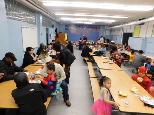 Dorman Elementary School parents enjoy a meal before playing superhero-themed games in a collaborative event with Springfield Housing Authority's Talk/Read/Succeed! program.