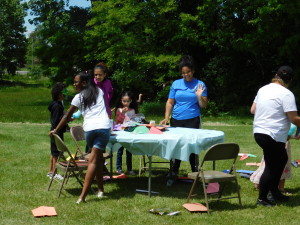 Youth counselors from the YMCA of Great Springfield help children make colorful paper airplanes at the celebration at Sullivan Apartments.
