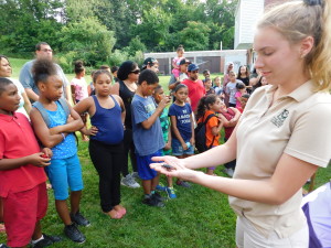 Savannah Marcotte, executive outreach coordinator at Forest Park's Zoo on the Go, shows Duggan Park residents a Madagascar hissing cockroach.
